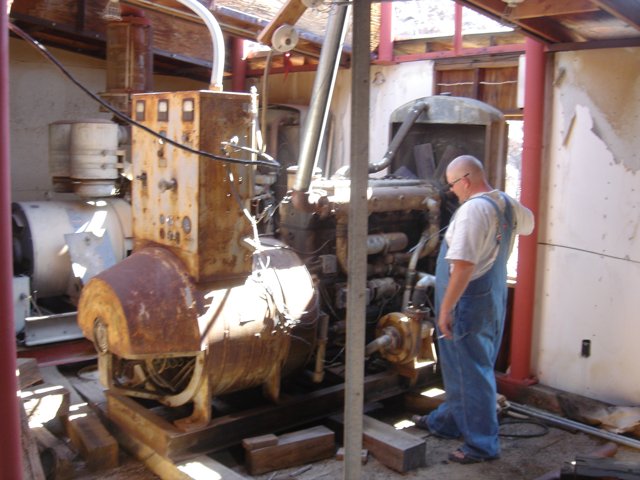 Man Standing Next to Large Factory Engine
