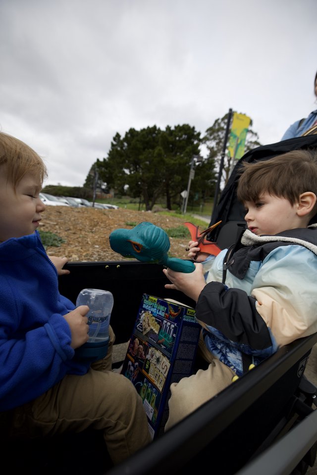 Two Young Boys Share Toys at Outdoor Playground