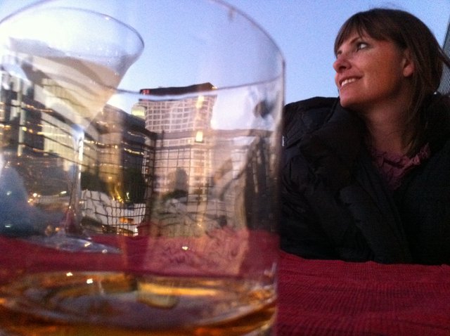 Rooftop Reverie: Woman Gazes at City Skyline at Dusk