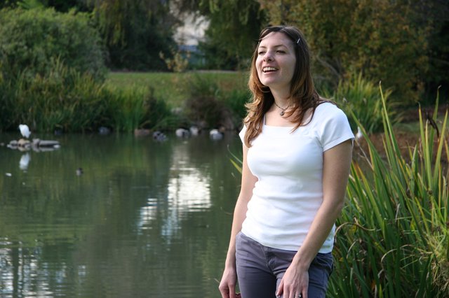 Joyful Woman Laughing by a Tranquil Park Pond