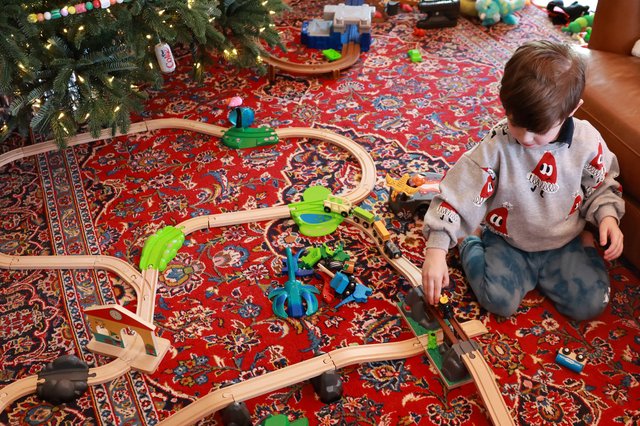 Child Playing with Wooden Train Set on Christmas