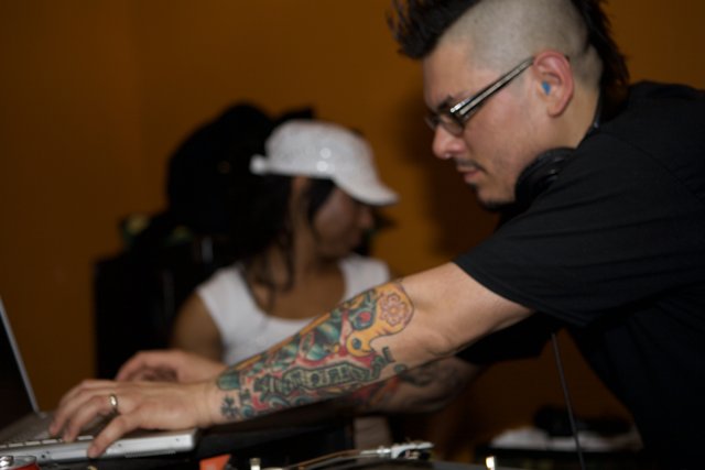 Black Shirted Deejay Flaunting Tattoos and Headphones