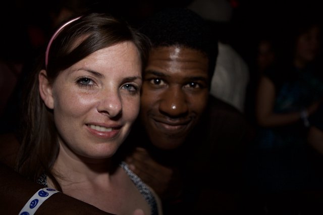Two Friends Smiling Together at a Nighttime Event