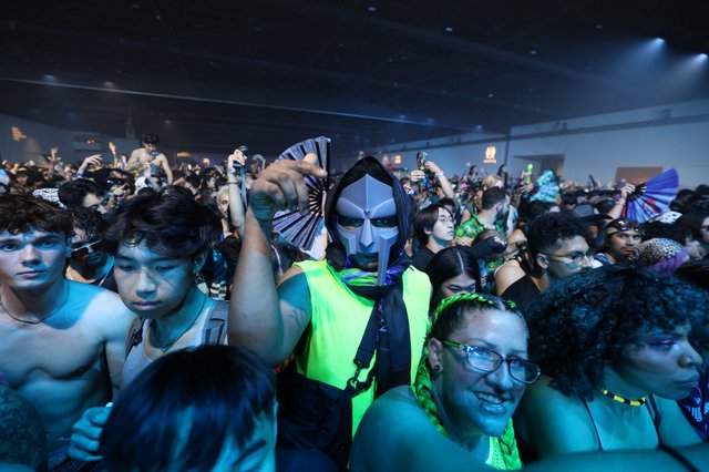 Masked Reveler Points at Camera in Festival Crowd