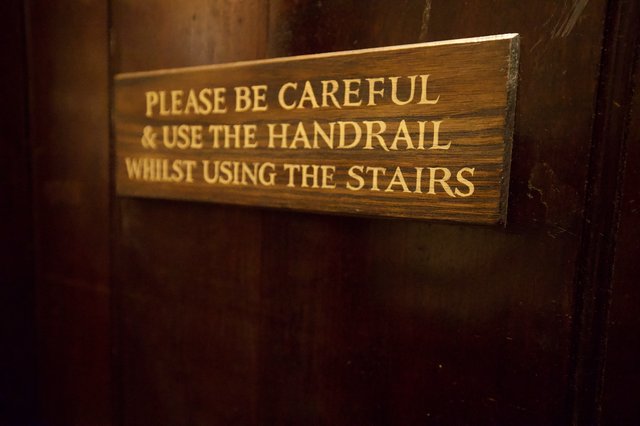 Historic Wooden Staircase Safety Sign in Old Building