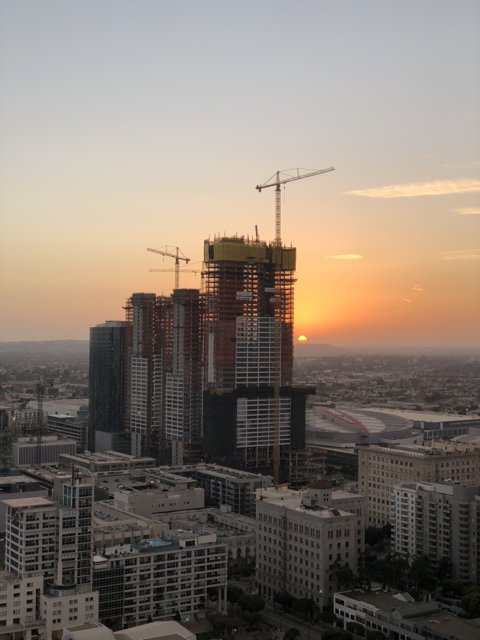 Urban Sunset over High-Rise Construction Site