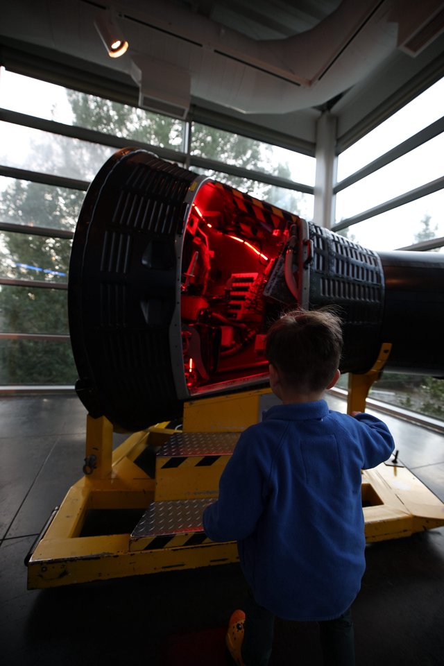 Child Observing Large Telescope Exhibit at Space Center