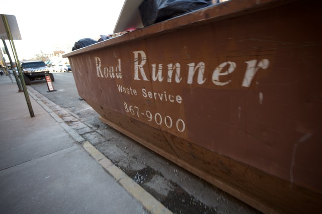 Road Runner Waste Service Dumpster on Urban Street