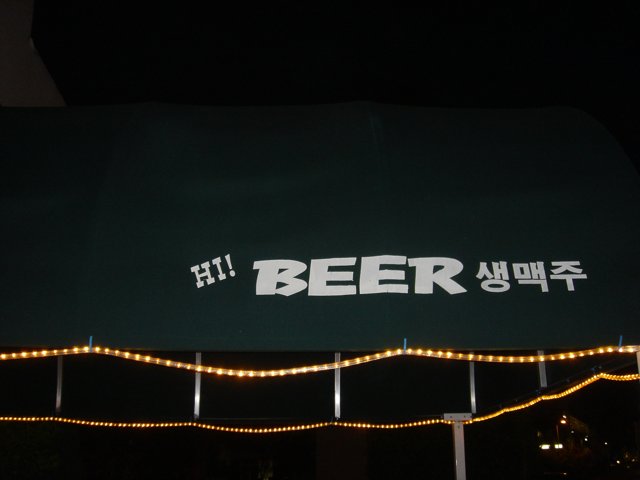 Green Canopy with Beer Sign at Night