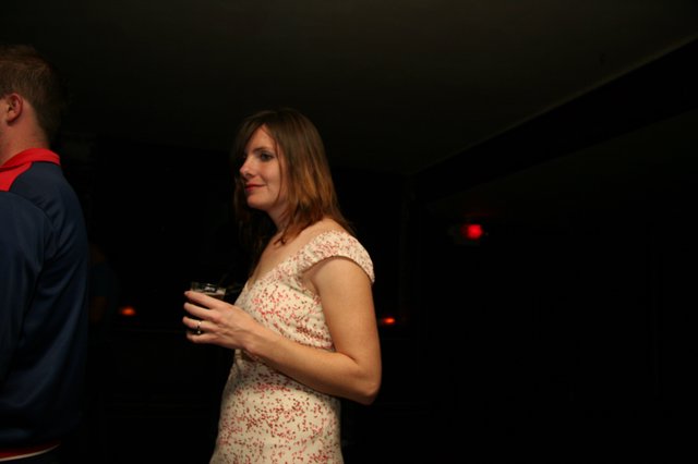 Woman in Floral Dress at Dimly Lit Venue