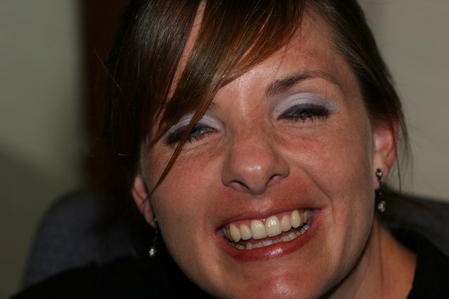 Joyful Woman Laughing at Indoor Social Gathering