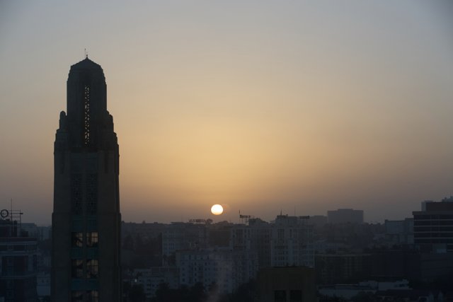 City Sunset Glows Behind Towering Skyscraper
