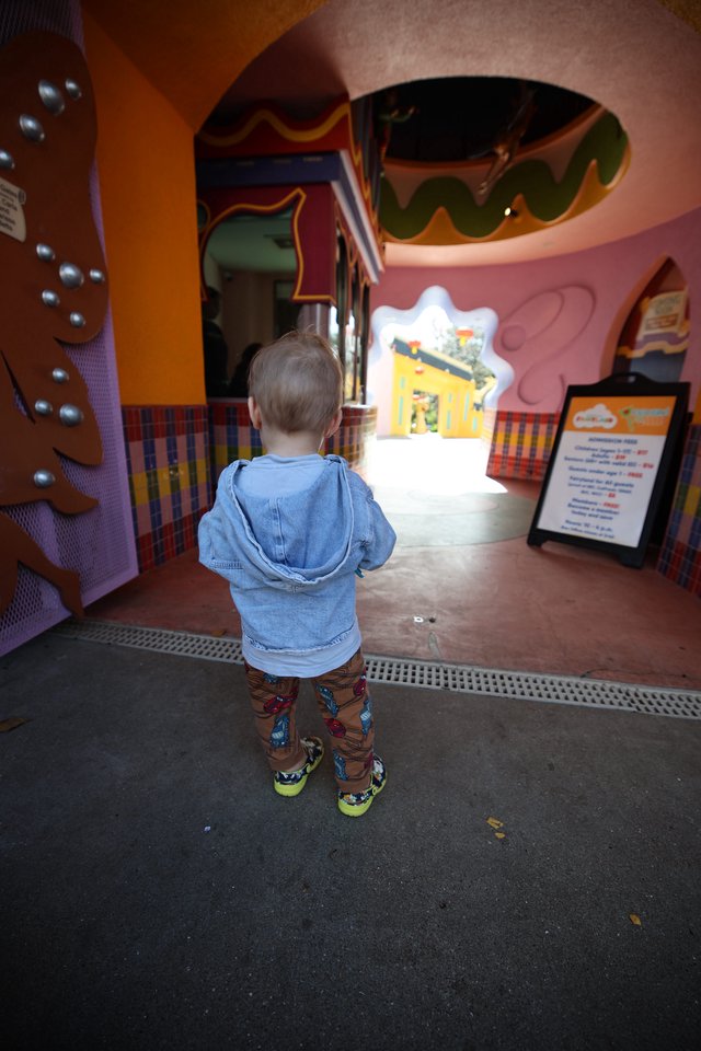 Young Child Explores Colorful Gingerbread House Attraction
