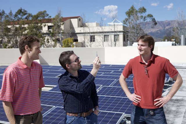 Three Men Harnessing Solar Power on a Rooftop