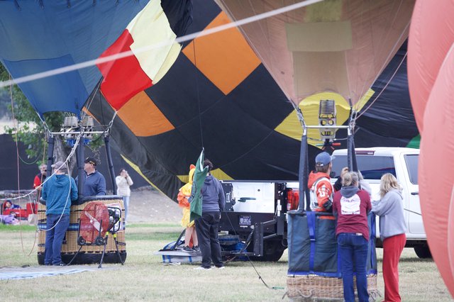 Ground Crew Inflating Colorful Hot Air Balloons at Festival