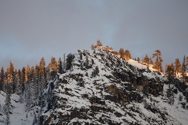 Snow-Covered Rocky Summit at Golden Hour in Winter