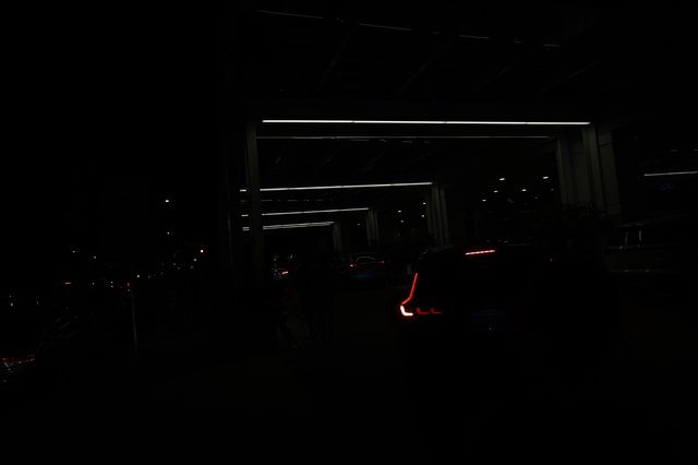 Red Taillights Glow in Dark Parking Structure Night