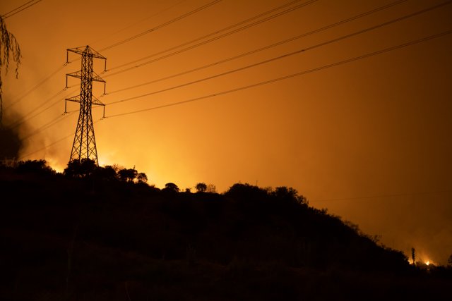 Blaze Engulfs Electric Transmission Tower and Surrounding Buildings