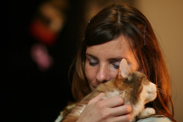 Woman Tenderly Nuzzles Orange Tabby Kitten Close