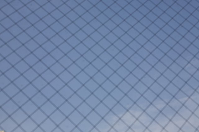 Texture of the Sky through a Chain Link Fence