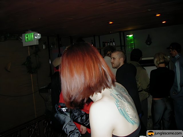 Red-haired Tattooed Woman Stands Out in Nightclub Crowd