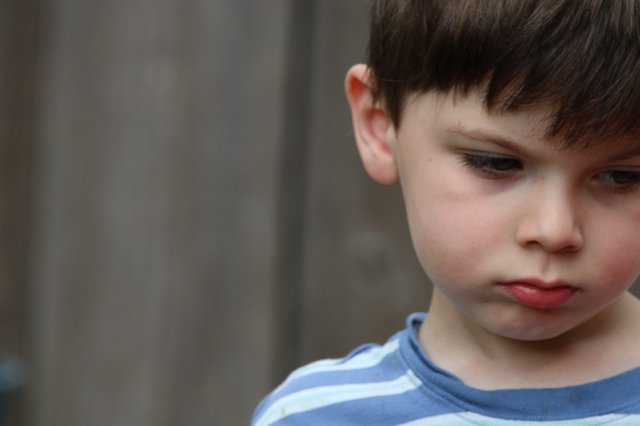 Contemplative Young Boy in Blue Striped Shirt