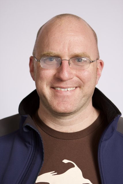 Smiling Man in Blue Jacket and Glasses