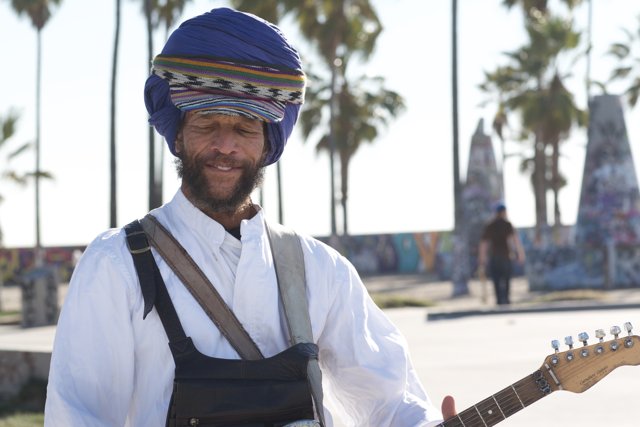 Turbaned Musician with a Guitar by the Palm Tree