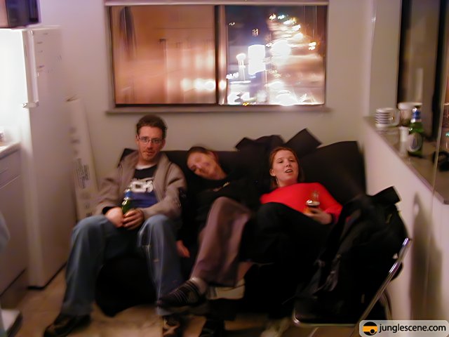 Three People Relaxing on a Cozy Living Room Couch