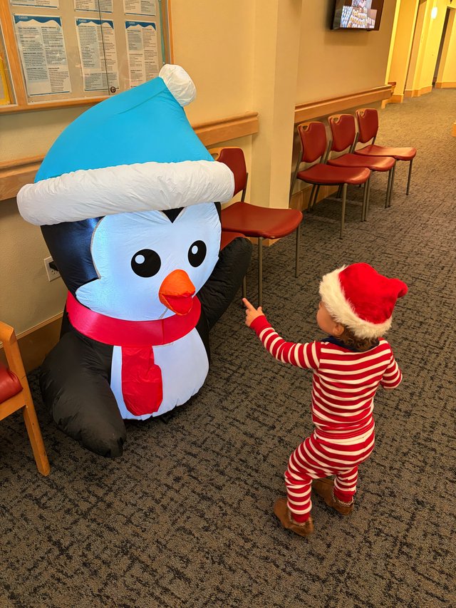 Child Meets Inflatable Snowman in Festive Holiday Setting