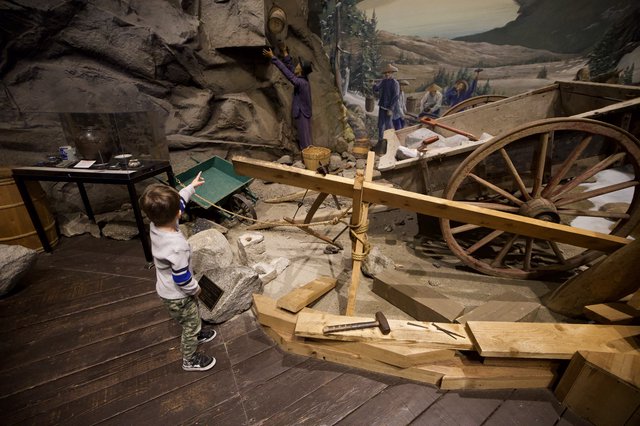 Young Child Exploring Interactive Gold Rush Mining Museum Exhibit