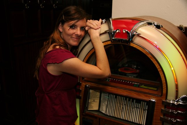 Retro Charm: Woman Poses with Classic Jukebox