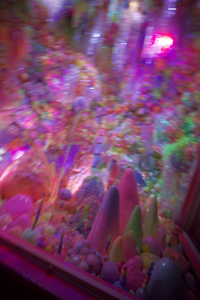 Motion Blur Through Neon-Lit Arcade Claw Machine