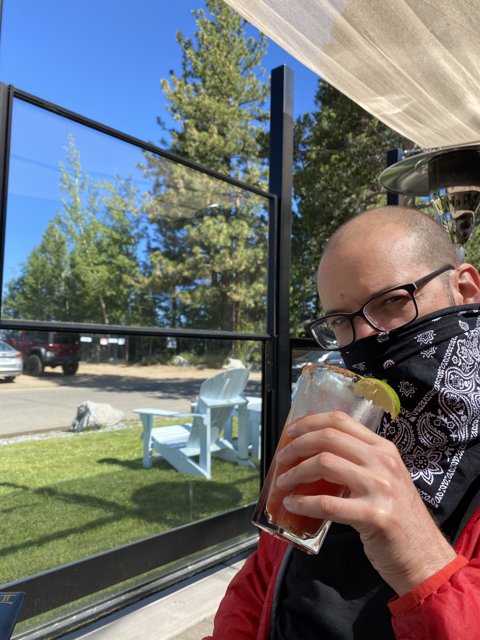 Bandana-Clad Dave B Enjoying a Drink Outdoors