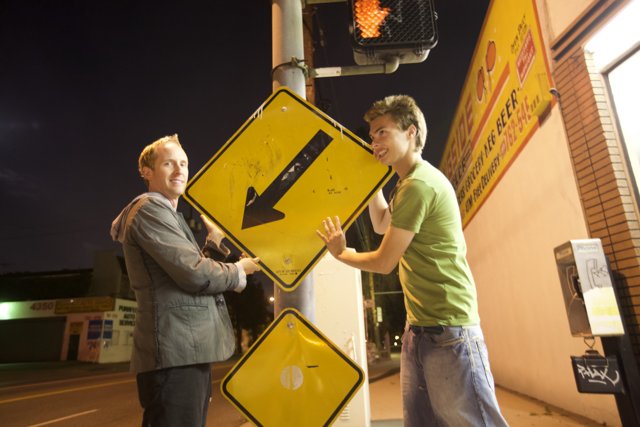 Two Men Next to a Symbolic Street Sign