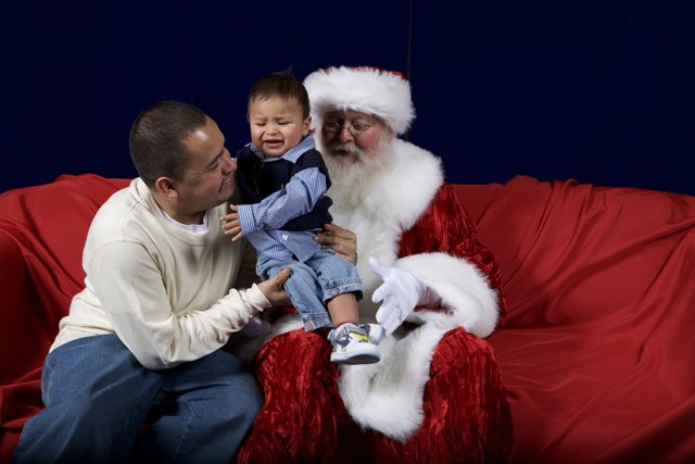 Santa Claus and a Little Helper on the Red Couch