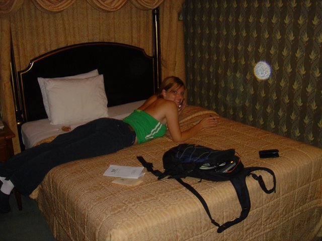 Traveler Relaxing on Hotel Bed with Backpack