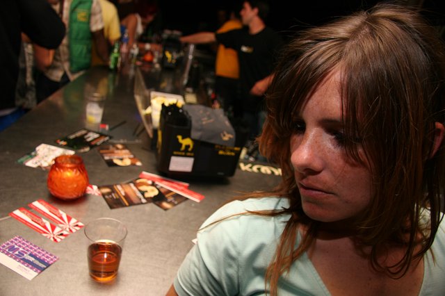 Pensive Young Woman at a Crowded Bar Counter