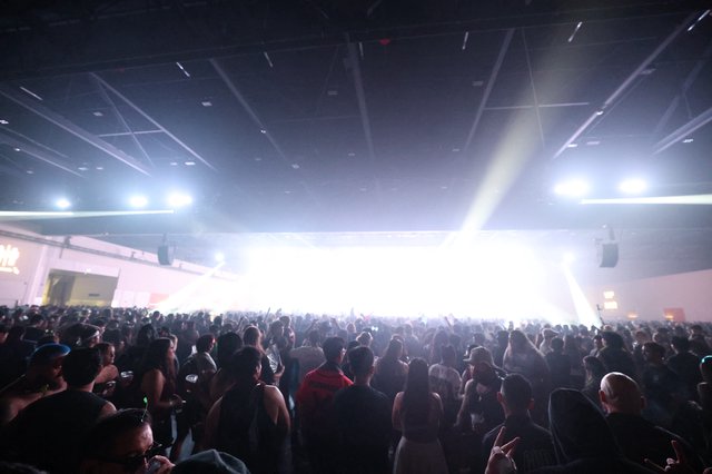 Massive Indoor Rave Crowd Bathed in Blinding Stage Light