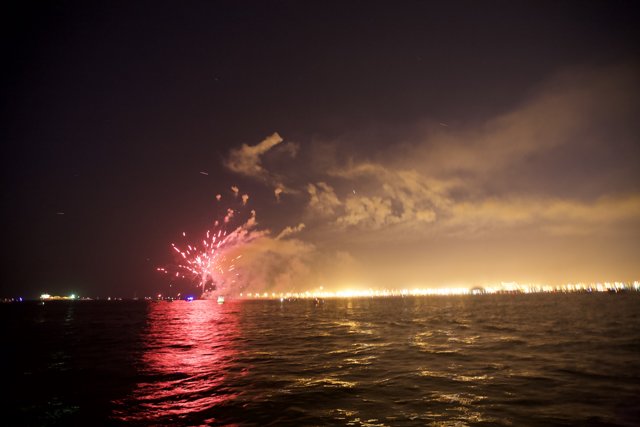 A Flare of Fireworks on the Water at Night