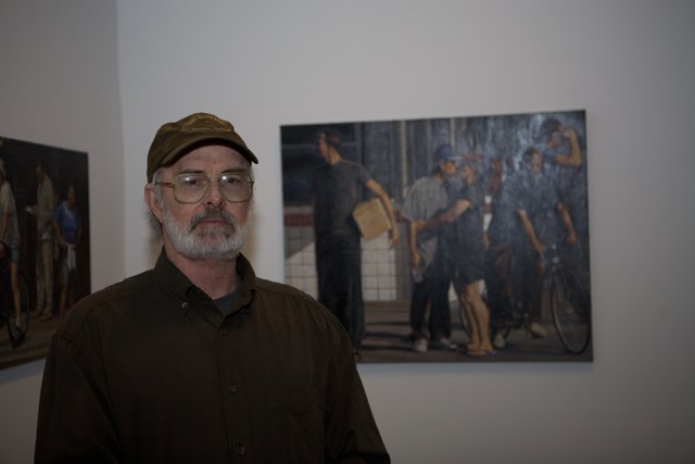 Man in Hat Admires Vibrant Paintings at Art Gallery