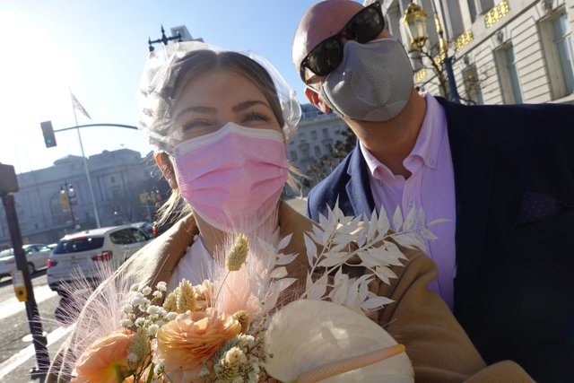 Masked Couple Walks Amidst Flower Beds on the Street