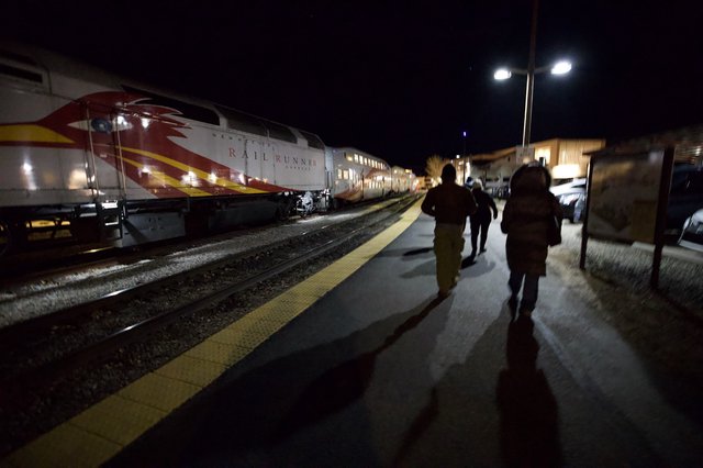 Passengers Boarding Rail Runner Express at Night