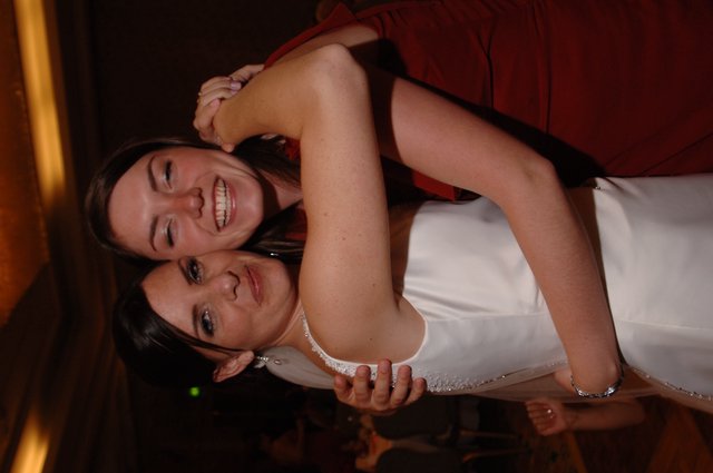 Bride and Bridesmaid Share Joyful Wedding Embrace