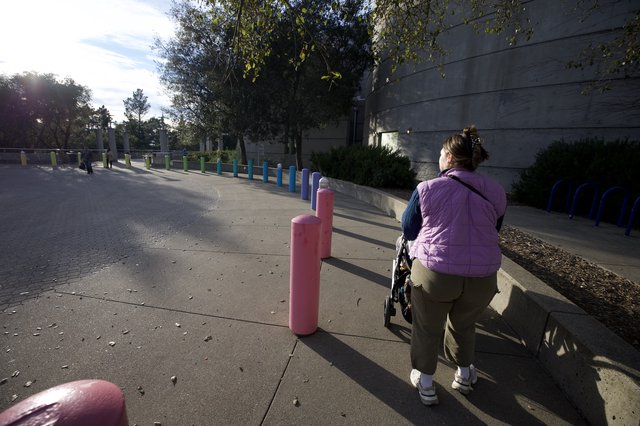 Woman Walking Past Colorful Posts at Chabot Space Center