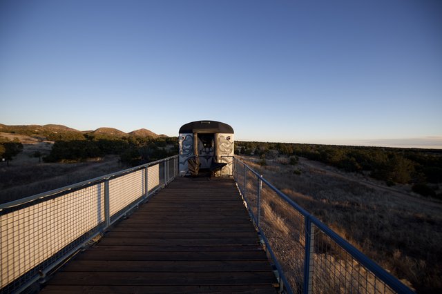 Wooden Boardwalk Leading to Desert Observation Structure at Dusk