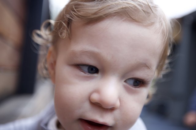 Curious Toddler with Blonde Curls Close-Up Portrait