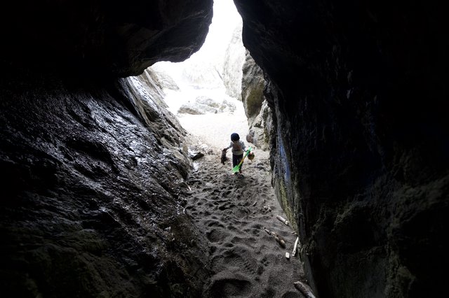 Young Explorer Ventures Into a Rocky Sea Cave