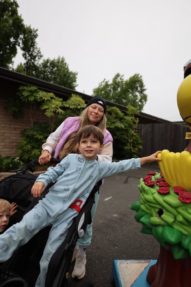 Boy Reaches for Hot Air Balloon Sculpture at Festival