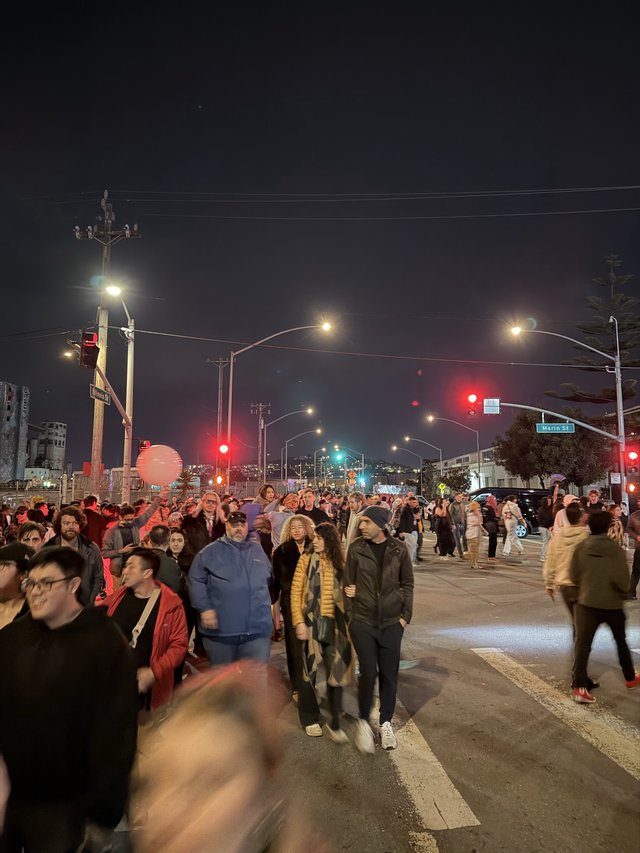 Night Street Scene with Large Crowd Gathering at Intersection